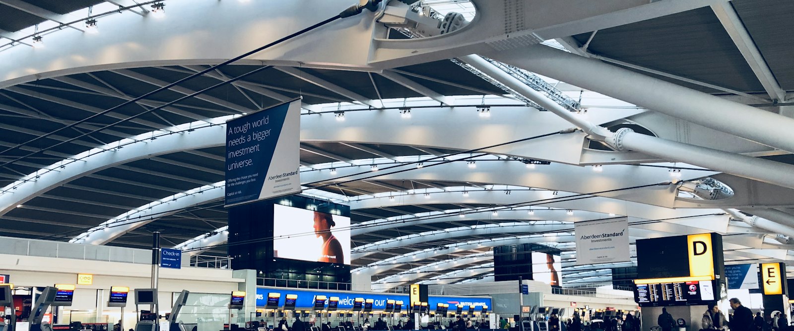 An airport departures hall with passengers heading for check-in
